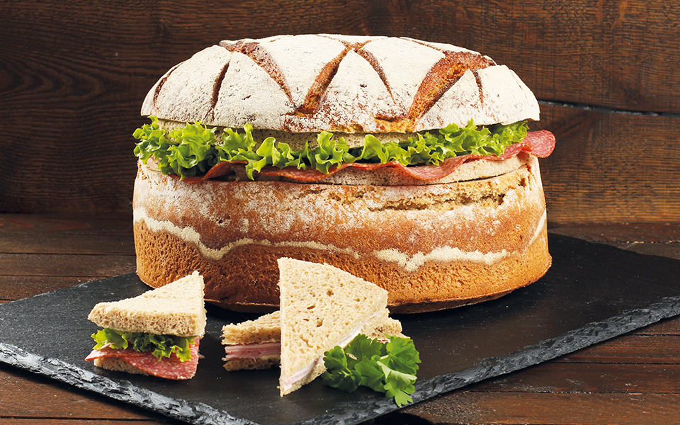 Brottorte mit Sandwich-Stücken im Vordergrund