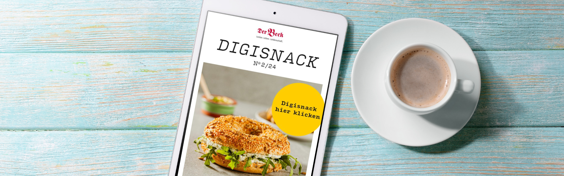Tablet mit geöffnetem DigiSnack und einer Tasse Kaffee auf  blauem Holzuntergrund