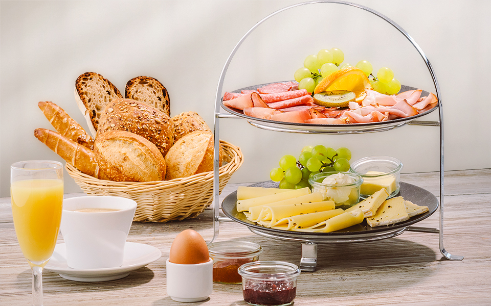Bild von einem Frühstück mit Brötchenkorb und Getränken